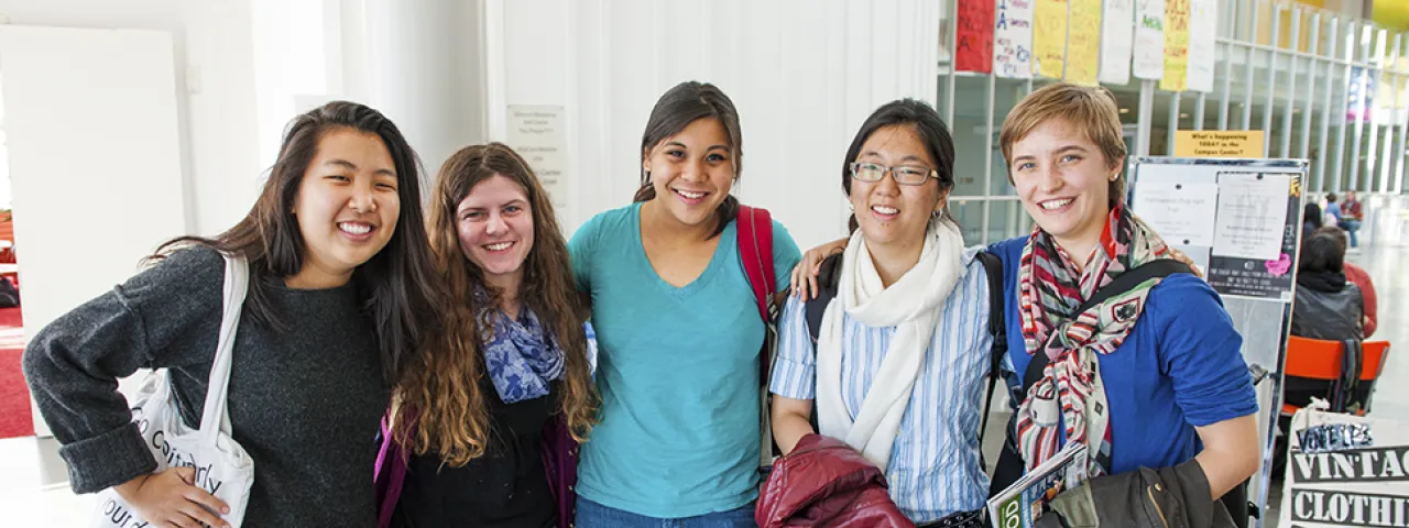 A group of smiling students posing in the Campus Center