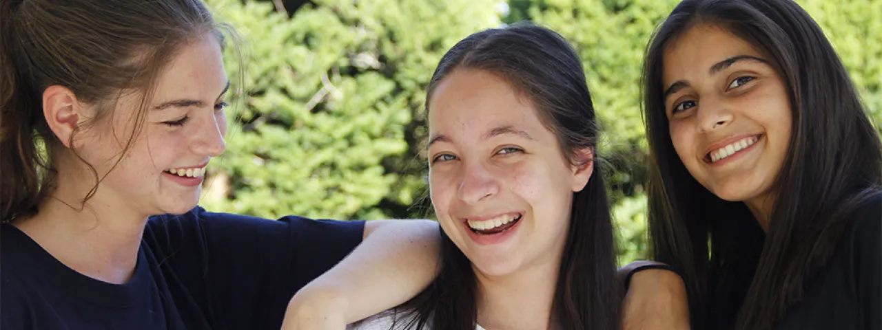 Three students laughing together