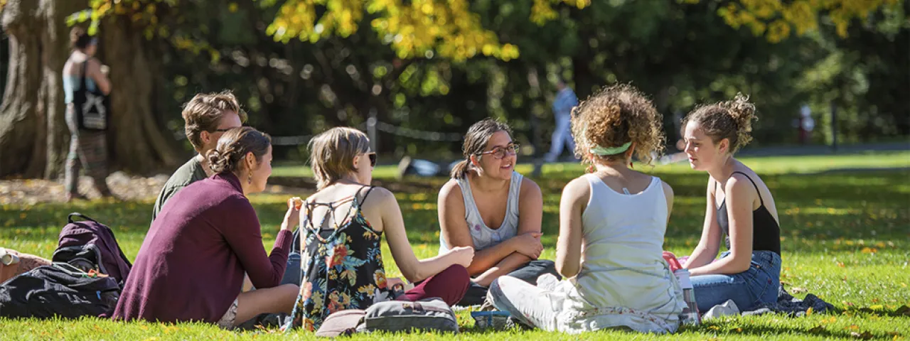 A group of students sitting on the lawn