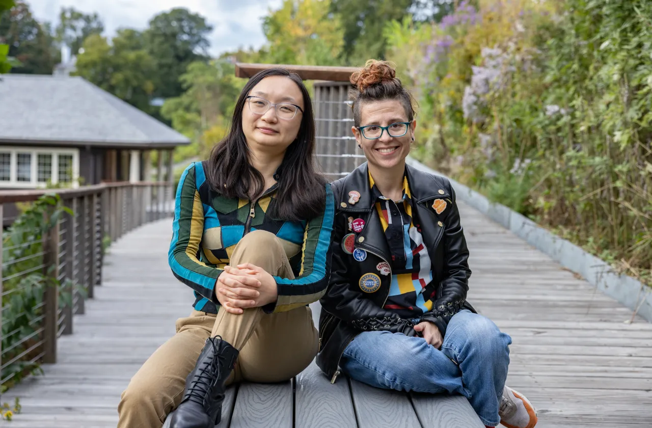 Shiya Cao and Heather Rosenfeld sit on a bench near Paradise Pond