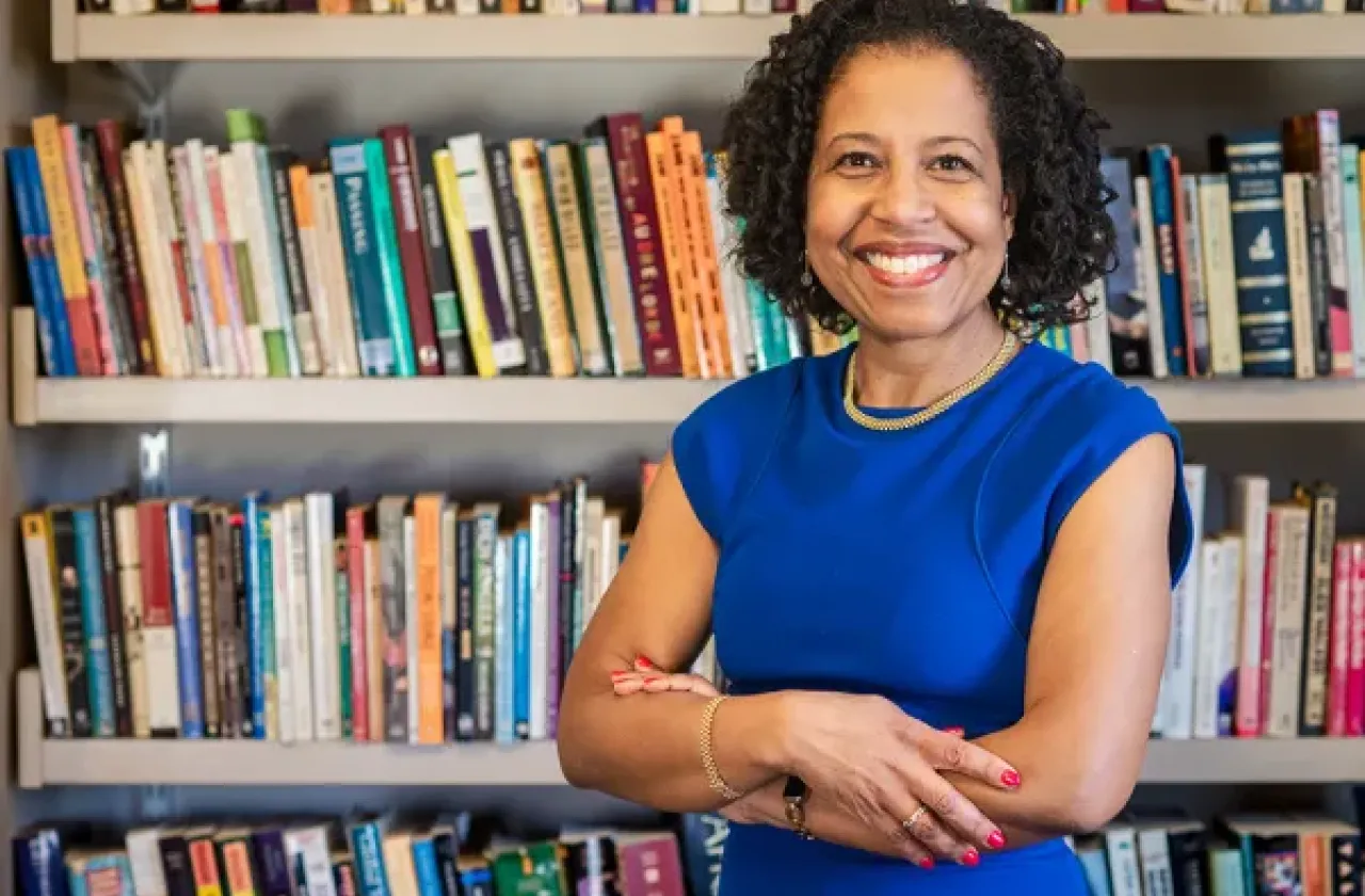 Daphne Lamothe smiles in front of some bookshelves.