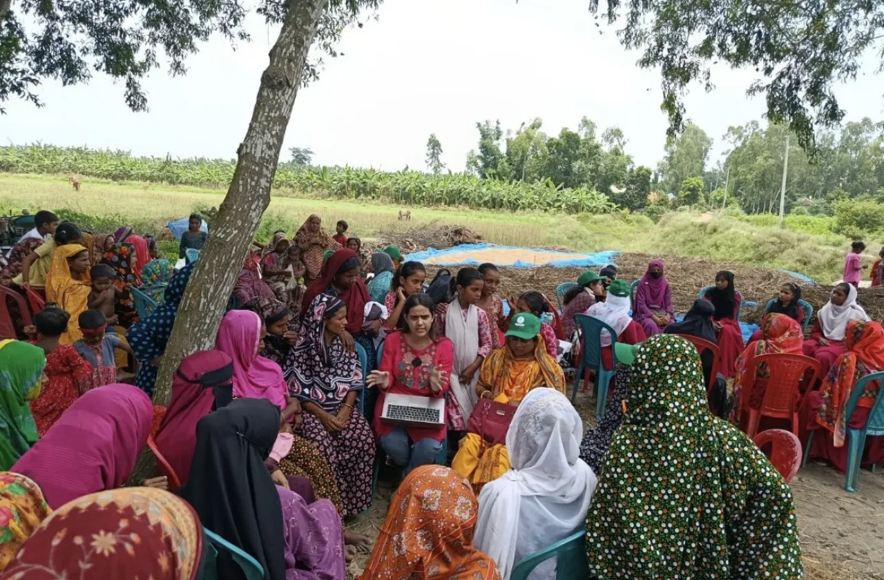 A group of rural Bangladeshi women gather in a circle to hear about a Davis Peace Project initiative led by Sagufta Anchal ’27.