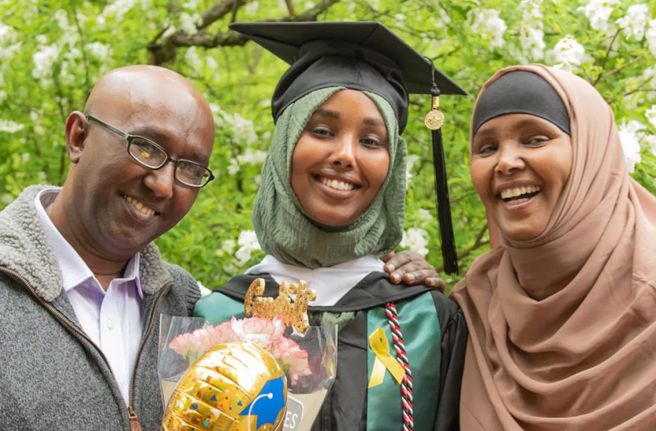 student in a hijab with her family at commencement
