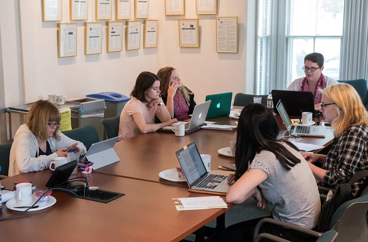 Students gathered around a table in the Kahn colloquium room