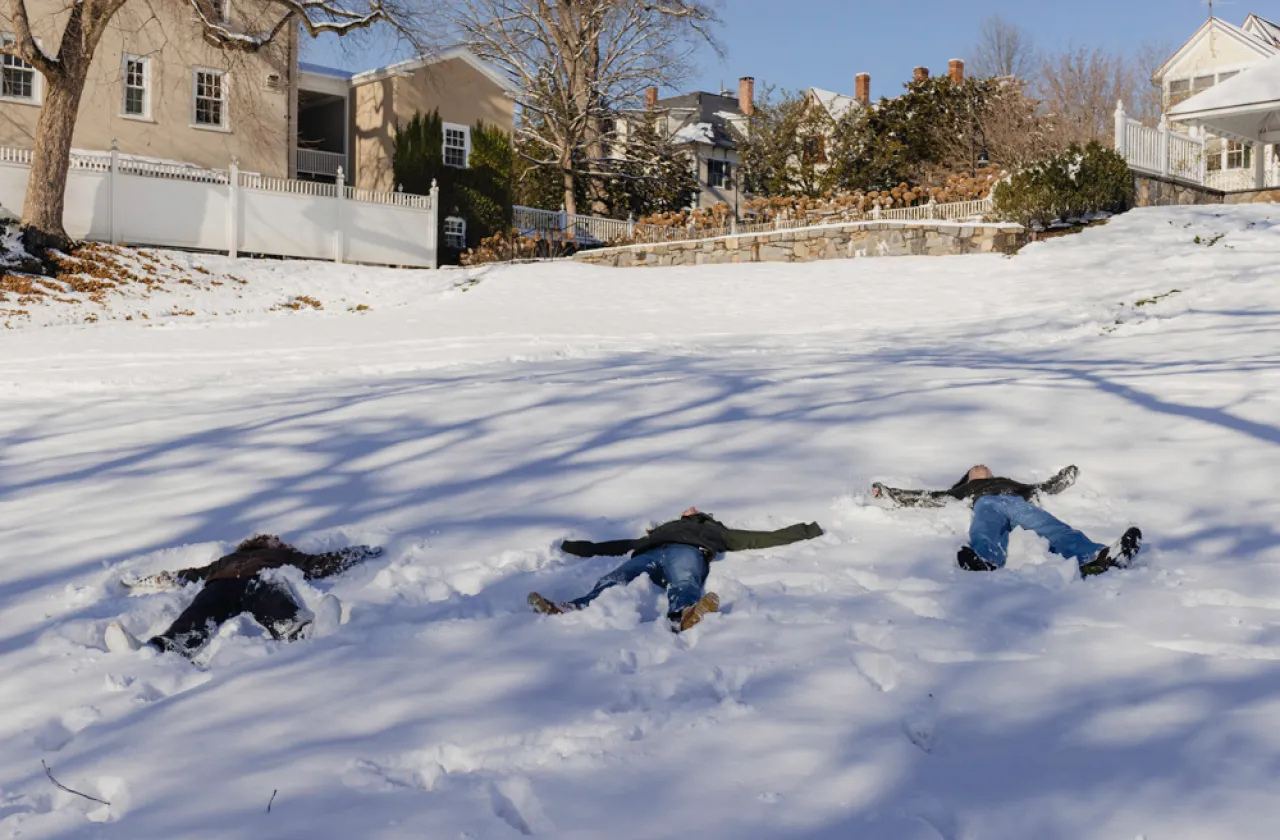 Three students creating snow angels