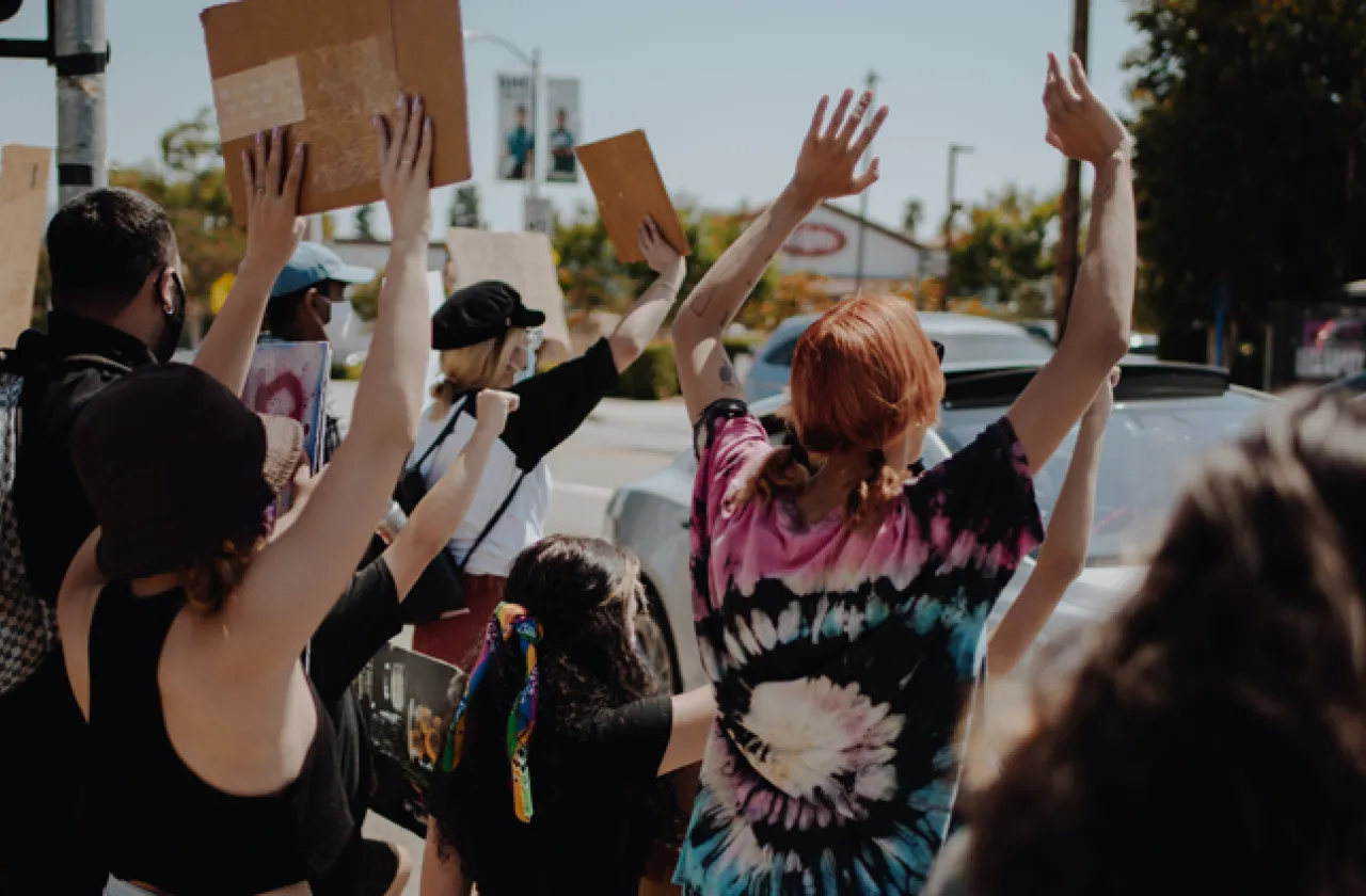 Unsplash photo showing backs of people who are holding signs at a protest