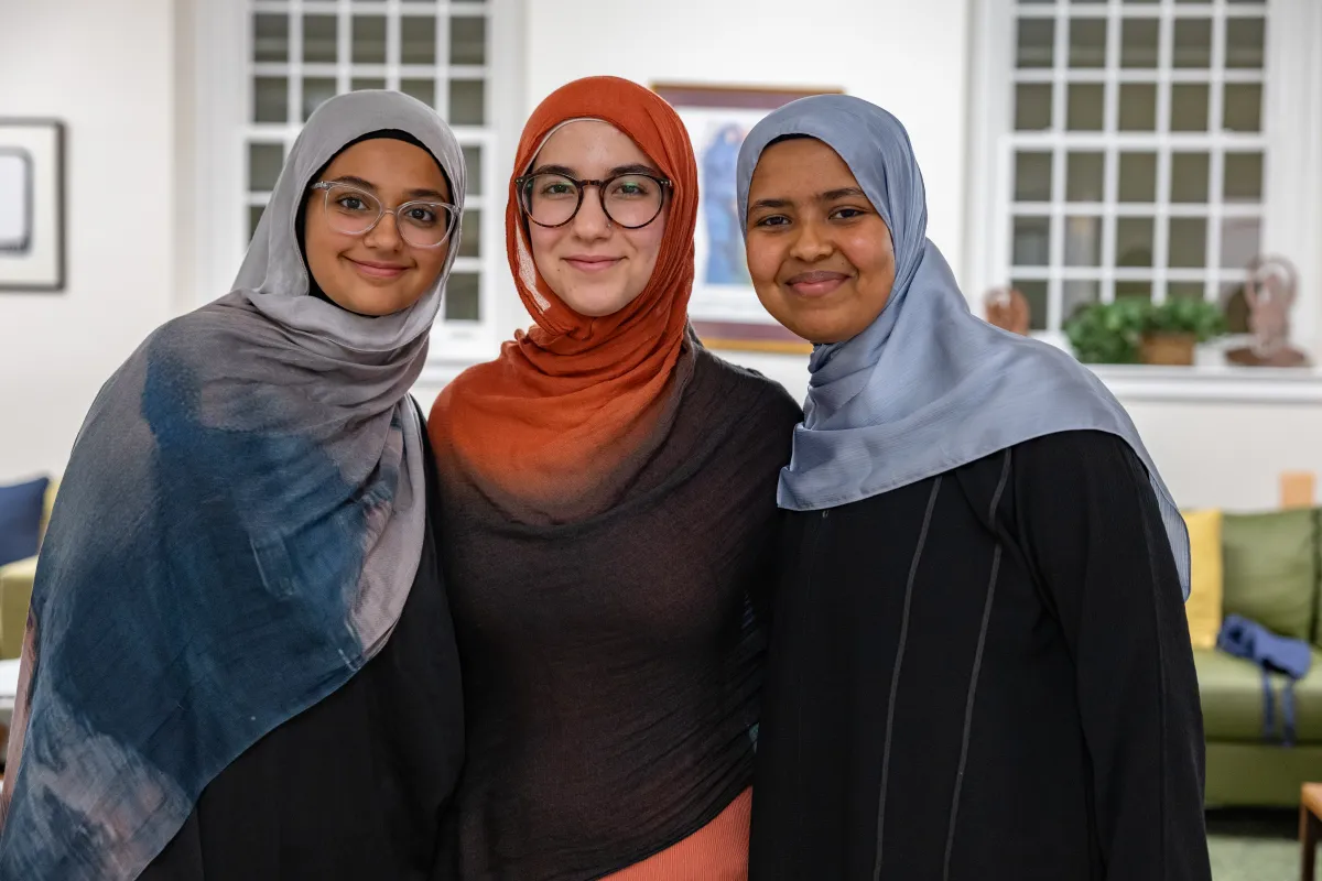 Three students smile at the camera