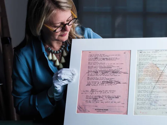 Dorothy Moss looking at documents she is holding up for the camera to see