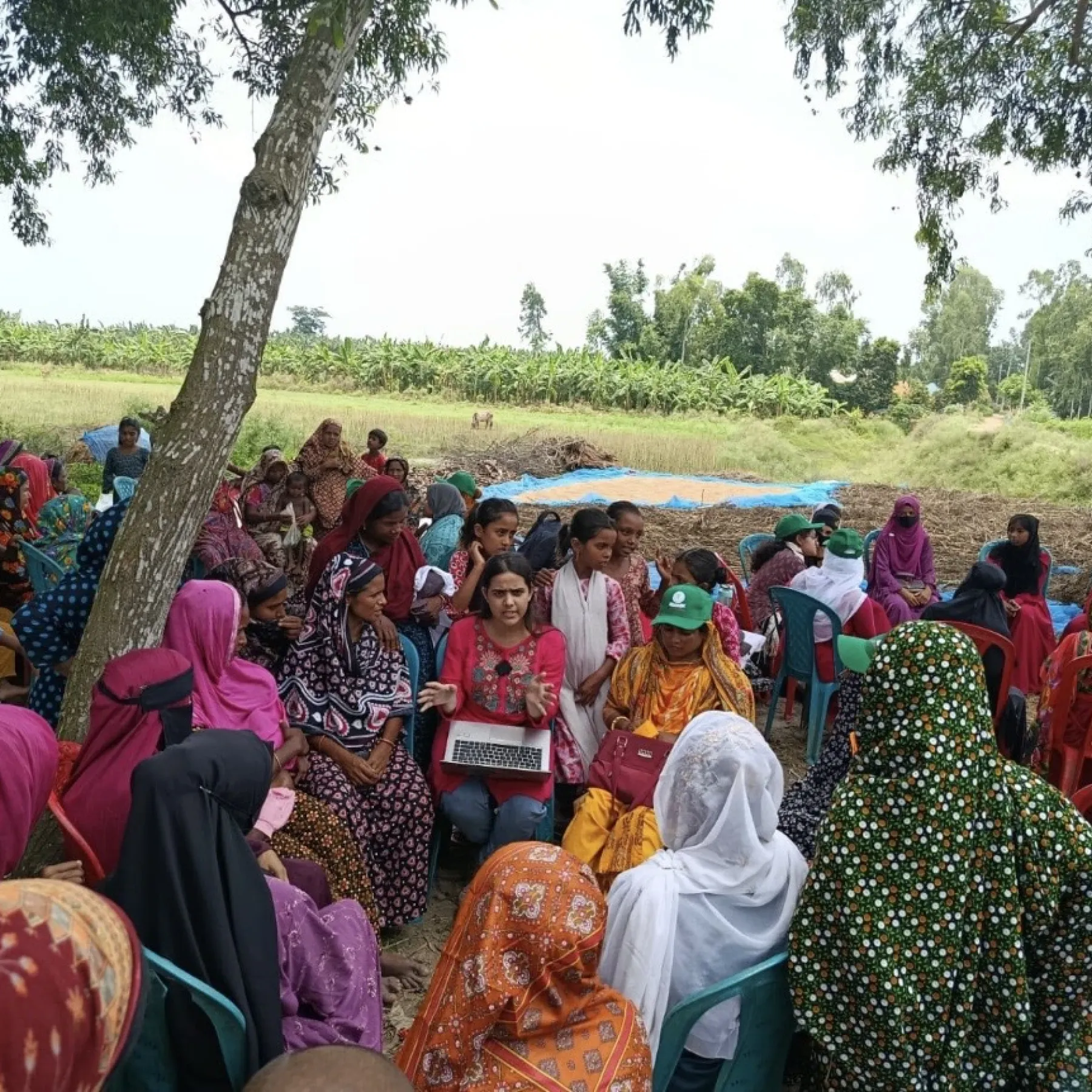 A group of rural Bangladeshi women gather in a circle to hear about a Davis Peace Project initiative led by Sagufta Anchal ’27.