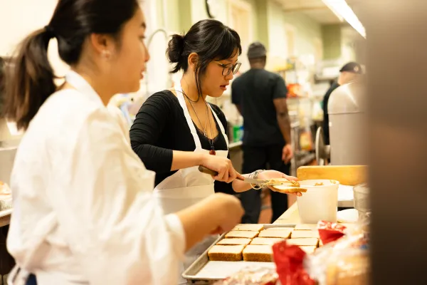 A student prepares food for IS Day 2025.