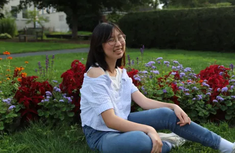 A student smiling in a garden at Smith.