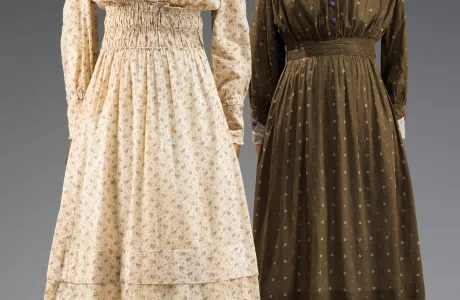 Cream and brown-colored long-sleeved dresses, cinched at the waists.