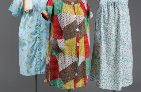 Three knee-length housecoats on mannequins with various patterns and colors.