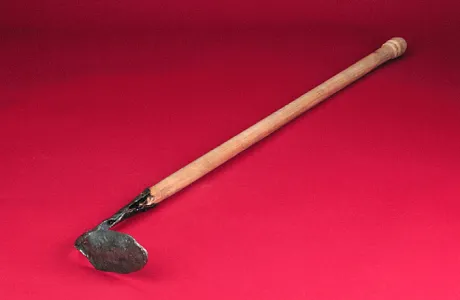 A wooden-handled hoe with a small, worn metal blade