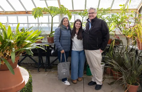 A Smithie poses with her parents in the greenhouse during Family Weekend.