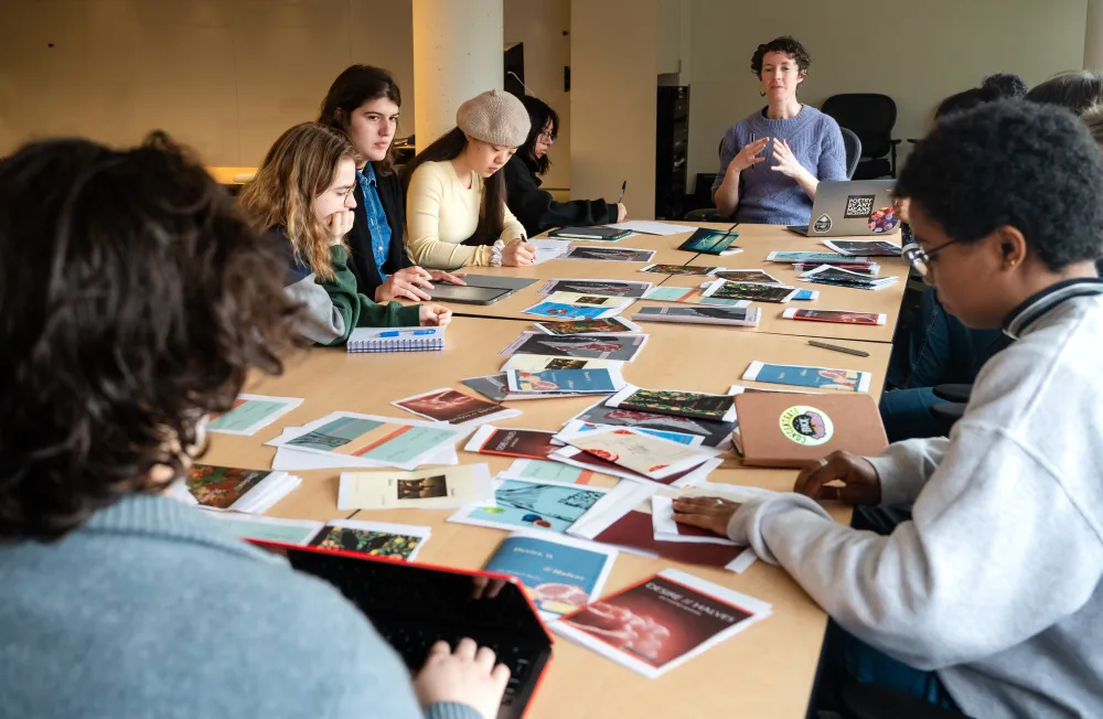Adrie Rose talks to a class of students seated around a long table