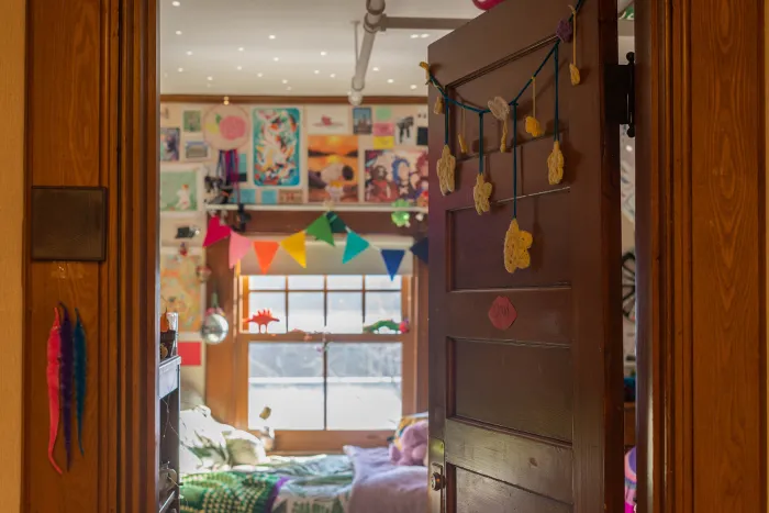 An open door looking into the colorfully decorated room of Cloud Osmond, class of 2024, in Morris House.