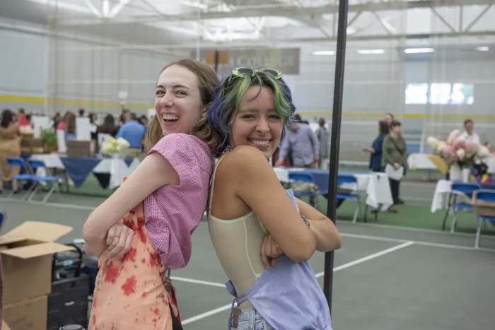 Two students pose for the camera with their arms crossed