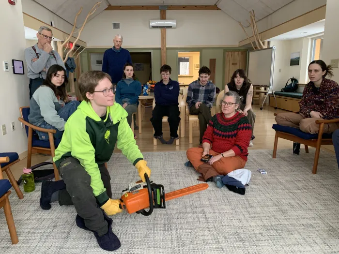 Cassandra Madru demonstrates how to safely hold a chain saw.