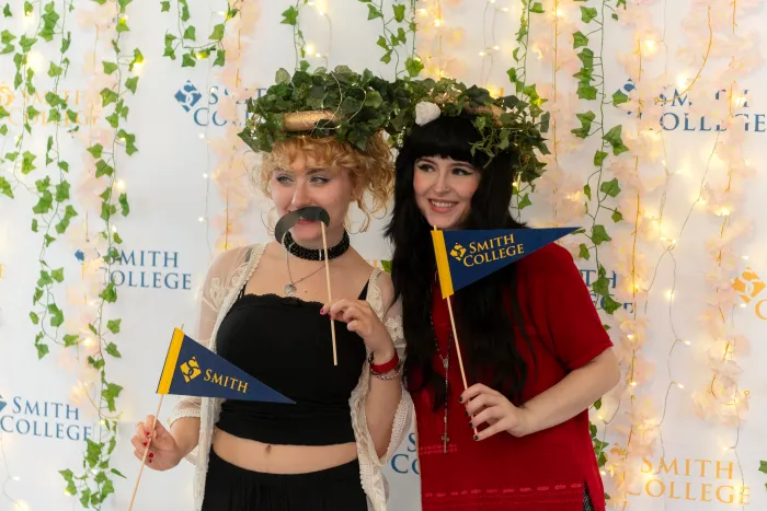 Students pose with props and Smith pennants in a photo booth