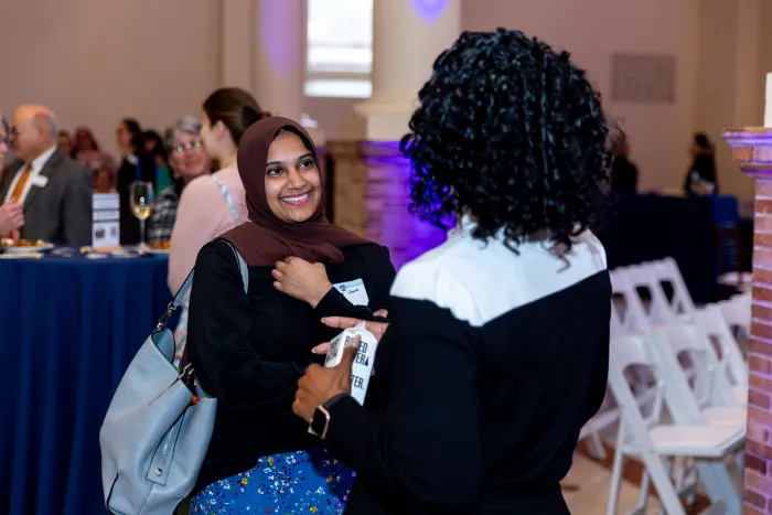 A young alum smiles in conversation.
