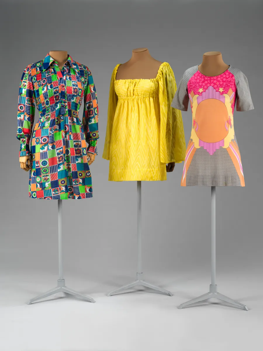 Very short-length dresses on mannequins in a variety of bright colors and patterns.