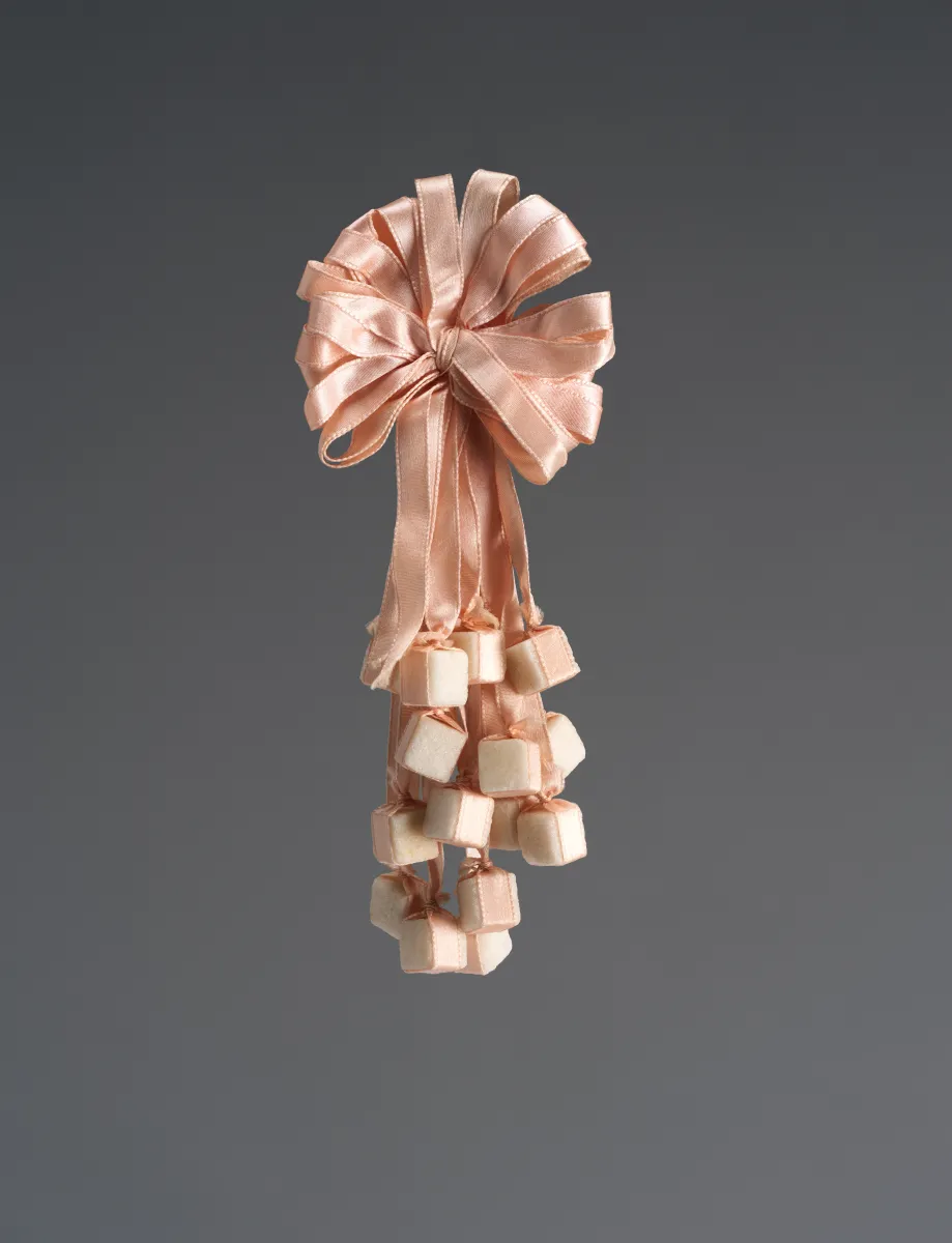 Light pink corsage made of ribbons and sugar cubes.
