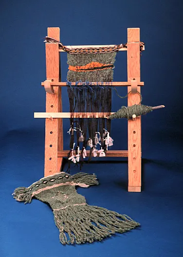 Wooden loom with fabric being woven and yarn hanging