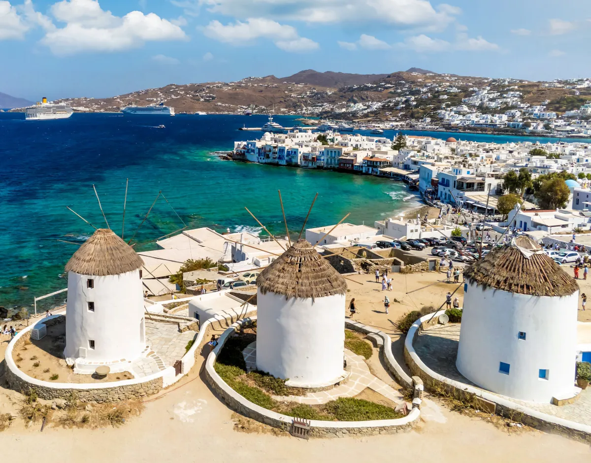 White buildings in Mykonos overlooking teal blue water