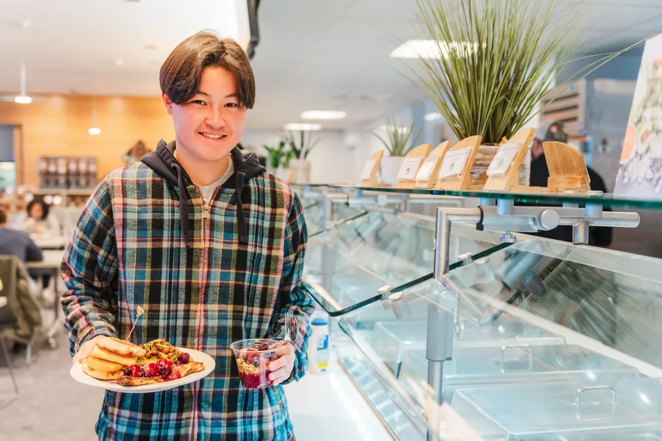 Student holds plates of plant-based breakfast foods in Cutter-Ziskind