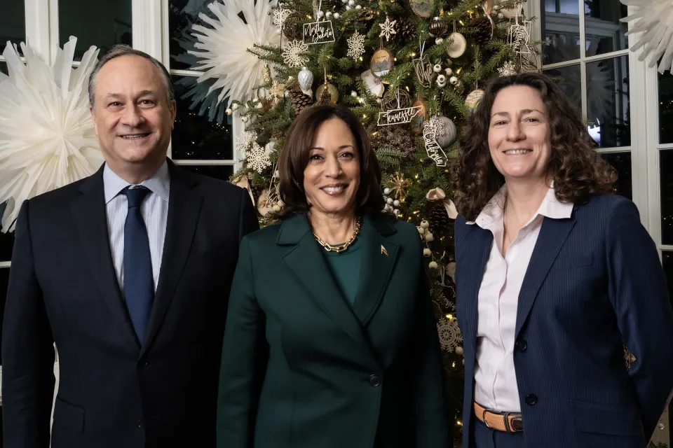 Second Gentleman Doug Emhoff, Vice President Kamala Harris, and Robin Brooks in front of a Christmas tree.