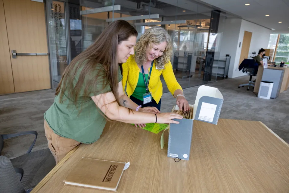 Leslie Fields helps Kady Wilson look through a box of files in Special Collections