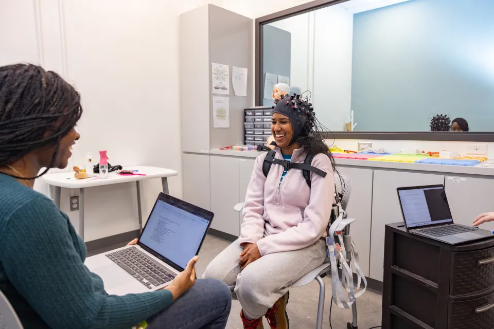 Student researcher Kris Cheaye works with lab participant Gloriamar Esteves in the MIND lab