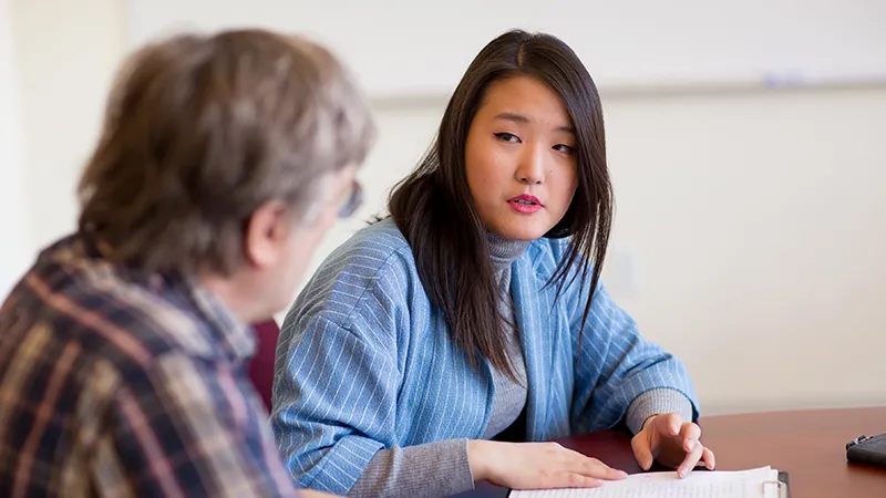 Faith Kim talking to a faculty member