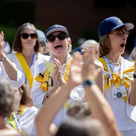 Smithies in blue baseball hats cheer during Reunion II