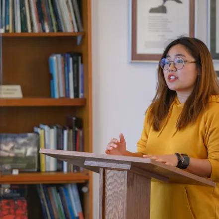 A student reading a poem at a podium