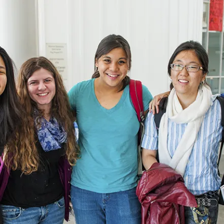 A group of smiling students posing in the Campus Center