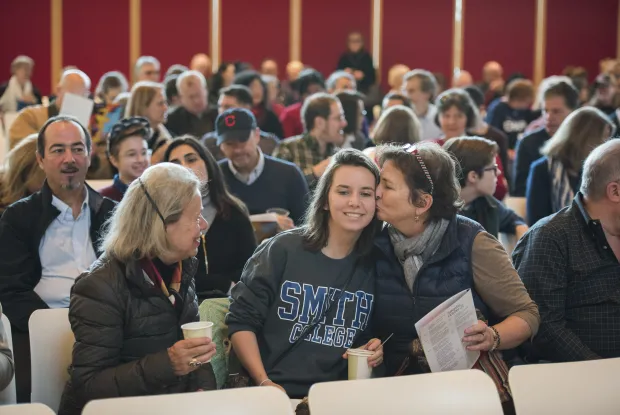 Student and their family at an assembly during Family Weekend.